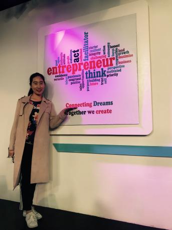 亚新体育
MBA 学生黄怿箴在丁丁电视创业LOGO处合影留念